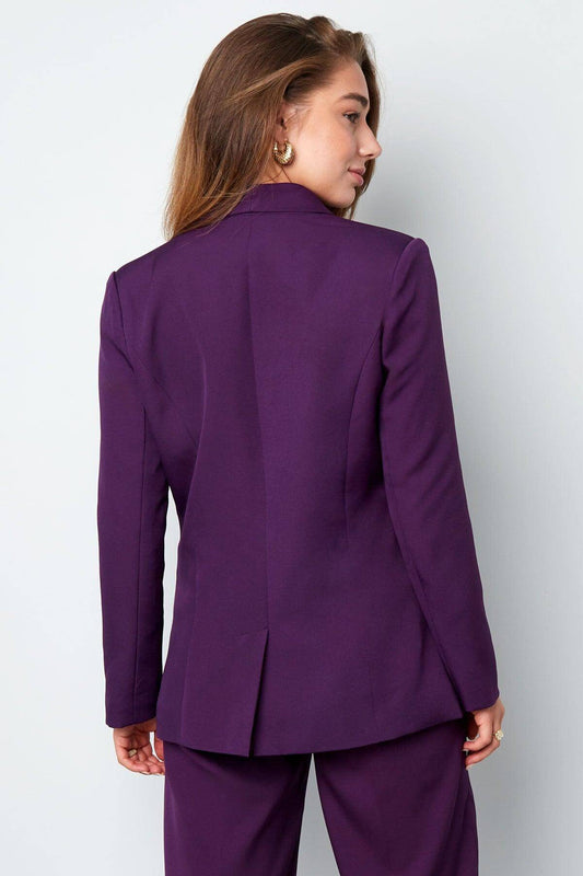 Woman wearing a purple vintage blazer with gold buttons, showcasing elegant and sophisticated design suitable for formal occasions.